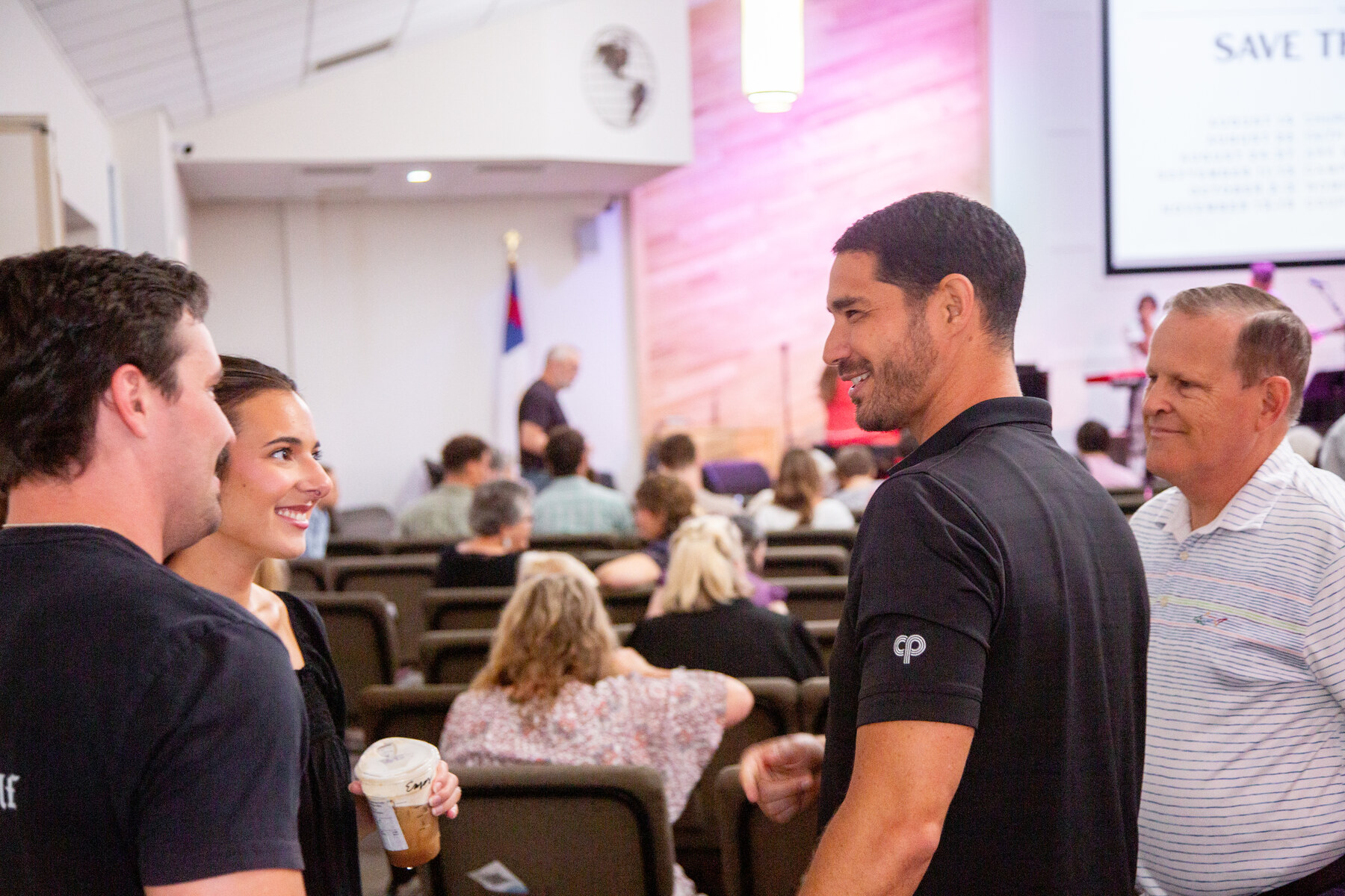 People greeting each other in the sanctuary before a service