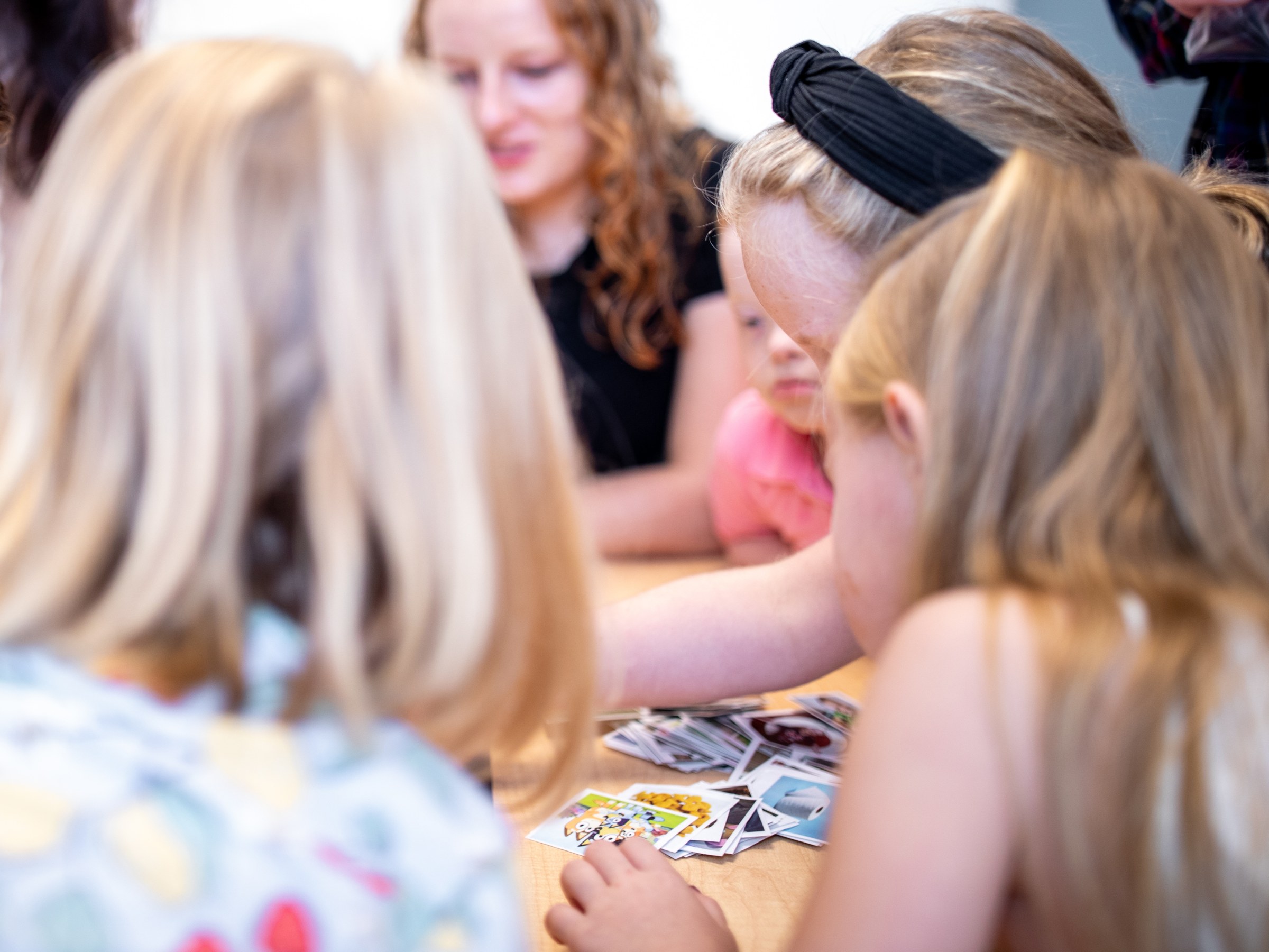 Children playing a card game around a table